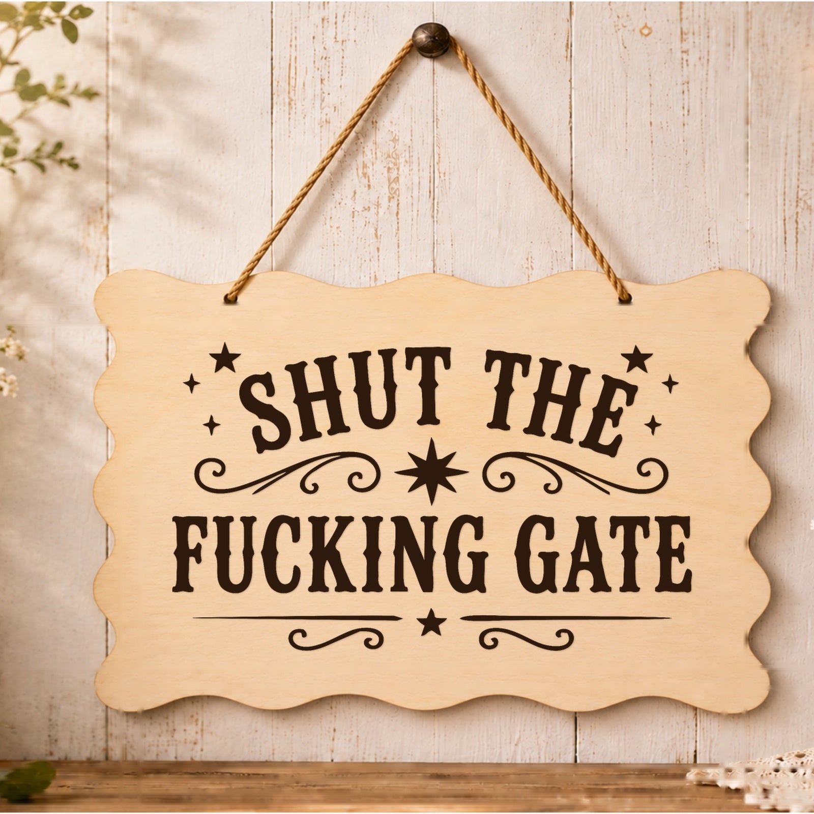 Shut the F**king Gate wooden plaque displayed by a garden gate
