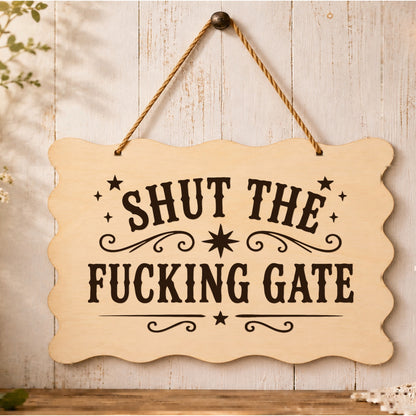 Shut the F**king Gate wooden plaque displayed by a garden gate