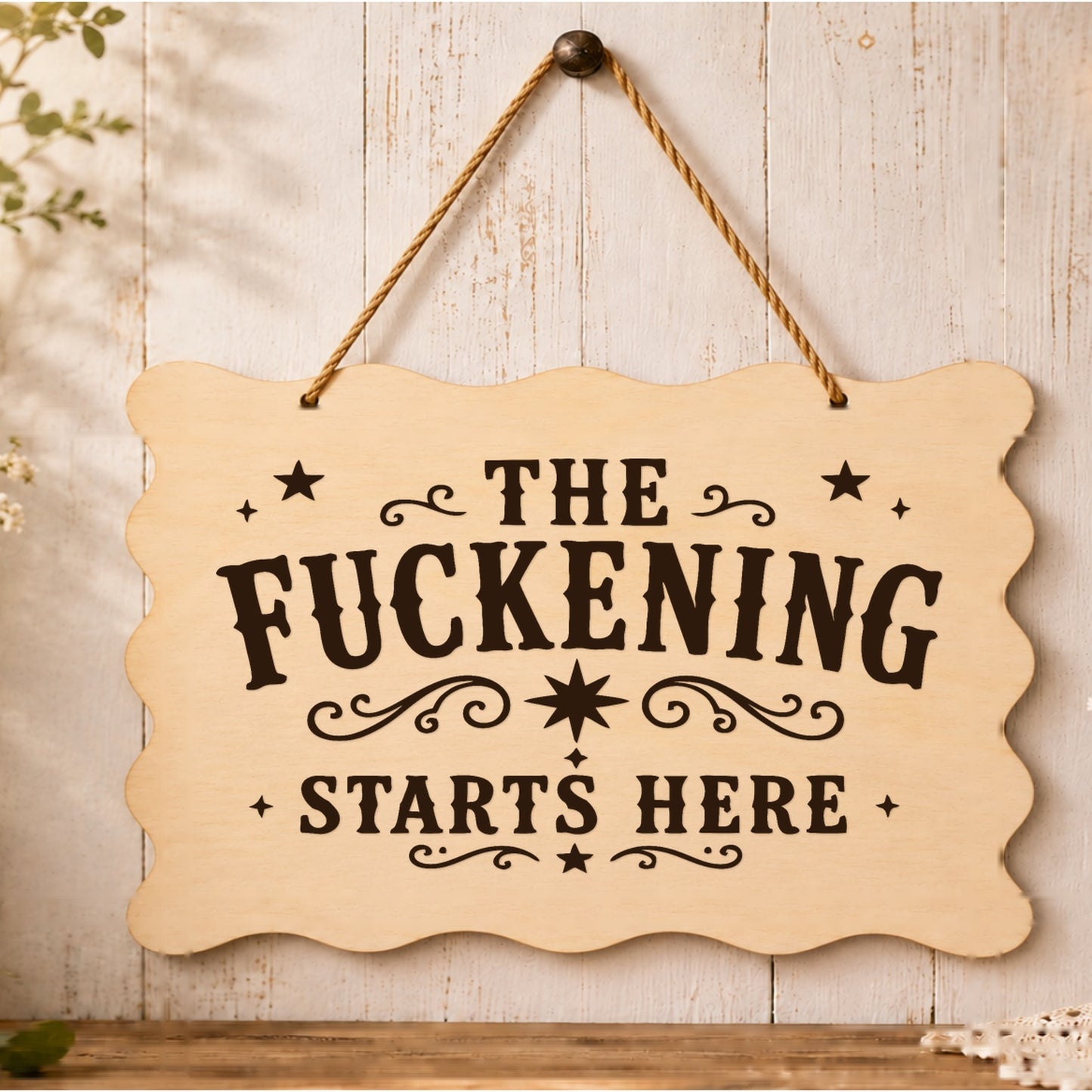 The F**kening Starts Here wooden plaque displayed in a home setting