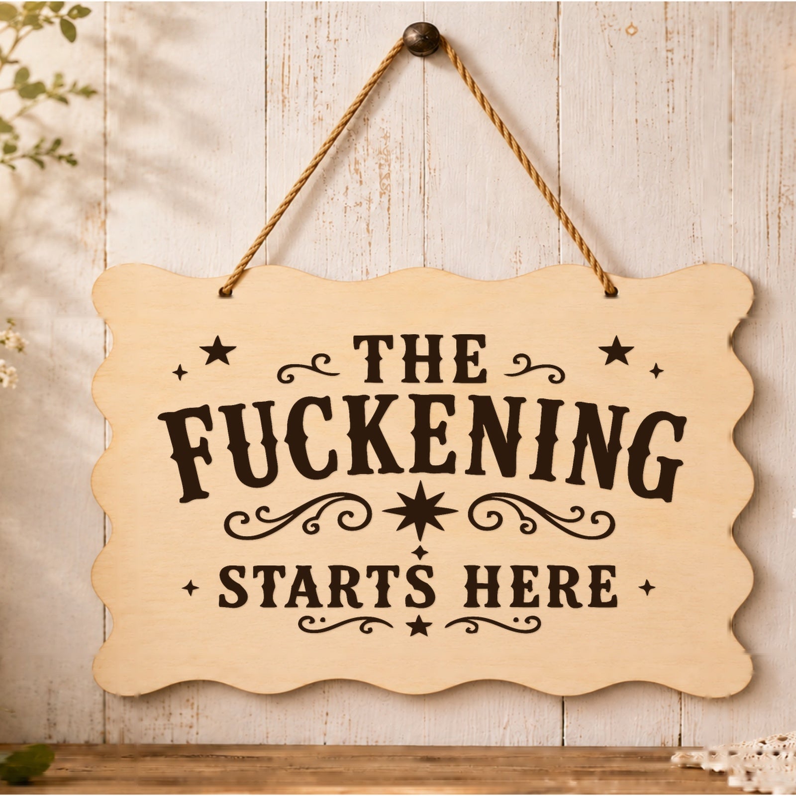 The F**kening Starts Here wooden plaque displayed in a home setting