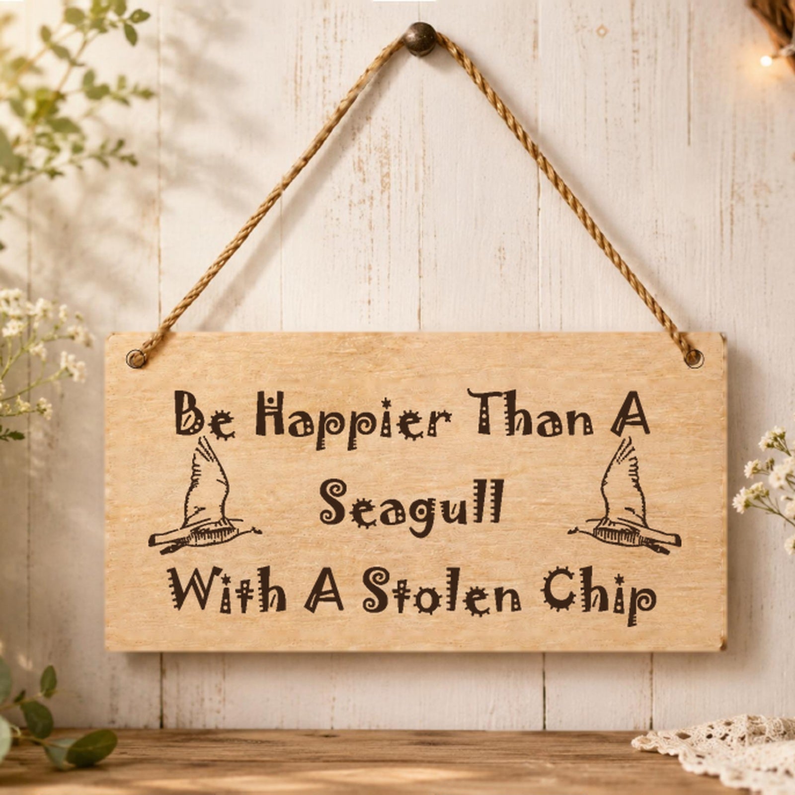 Happier Than a Seagull With a Chip plaque displayed in a coastal setting
