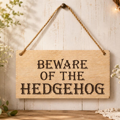 Beware of the Hedgehog wooden plaque displayed in a garden setting