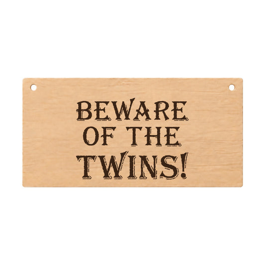 Beware of the Twins funny laser engraved wooden plaque on a white background