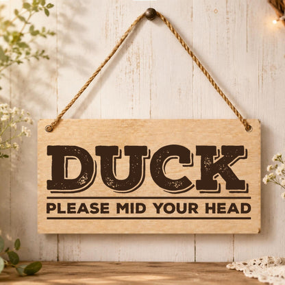 Duck Please Mind Your Head wooden plaque displayed by a doorway