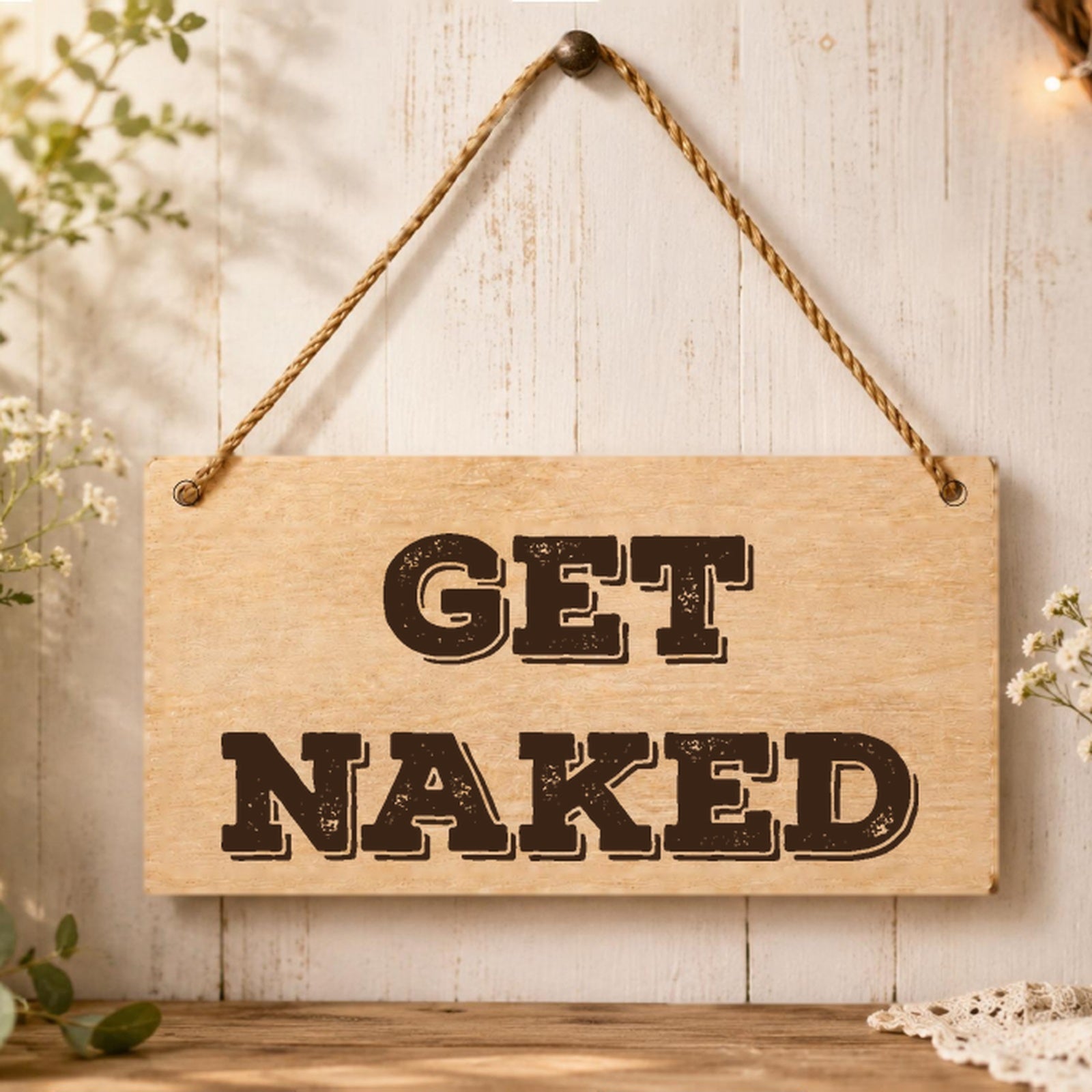 Get Naked wooden plaque displayed in a bathroom setting
